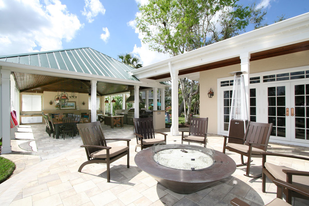 Immagine di un ampio patio o portico costiero dietro casa con pavimentazioni in cemento e un tetto a sbalzo