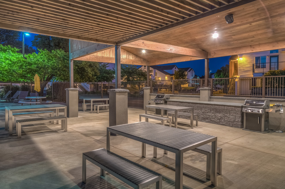 Cette photo montre une grande terrasse moderne avec une cuisine d'été, une cour, une dalle de béton et une pergola.