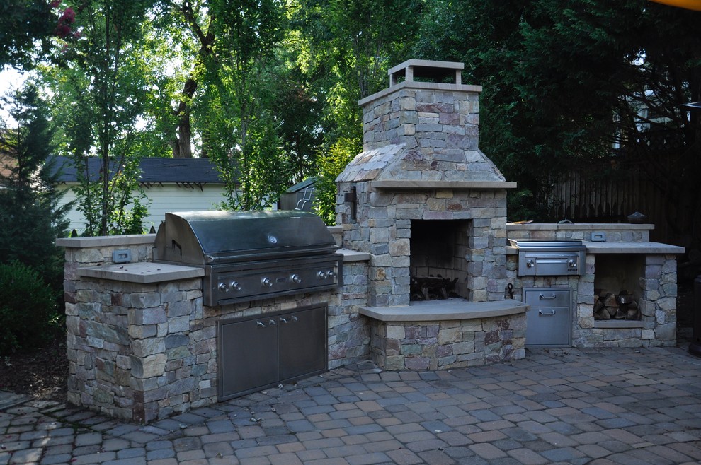This is an example of a medium sized traditional back patio in DC Metro with an outdoor kitchen, brick paving and no cover.