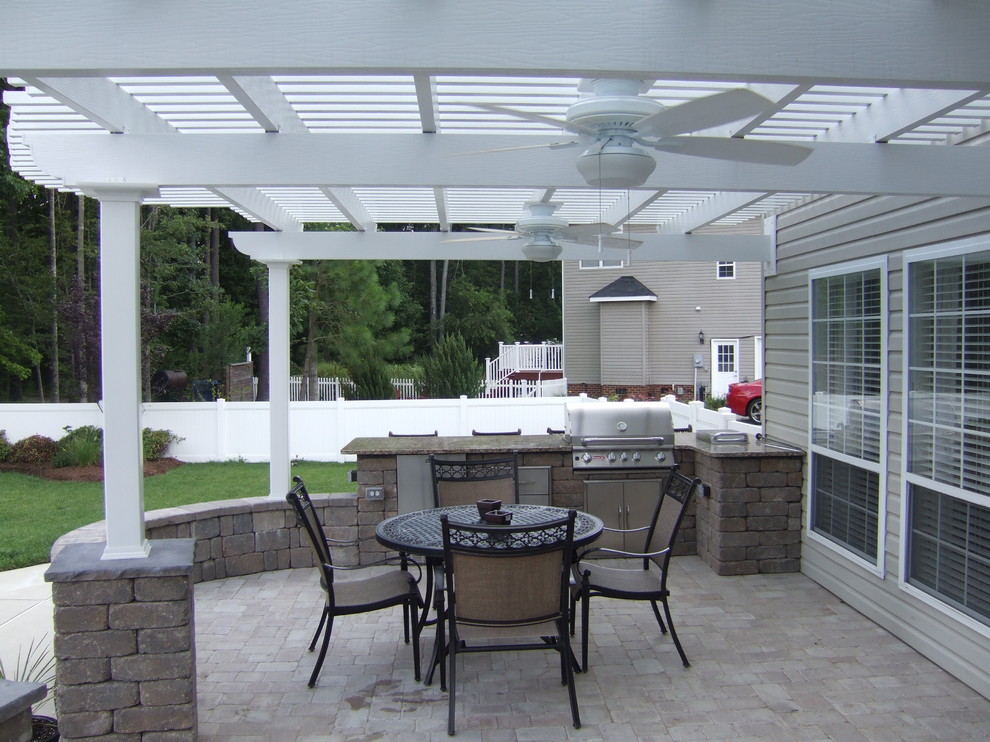Imagen de patio clásico grande en patio trasero con pérgola, cocina exterior y losas de hormigón