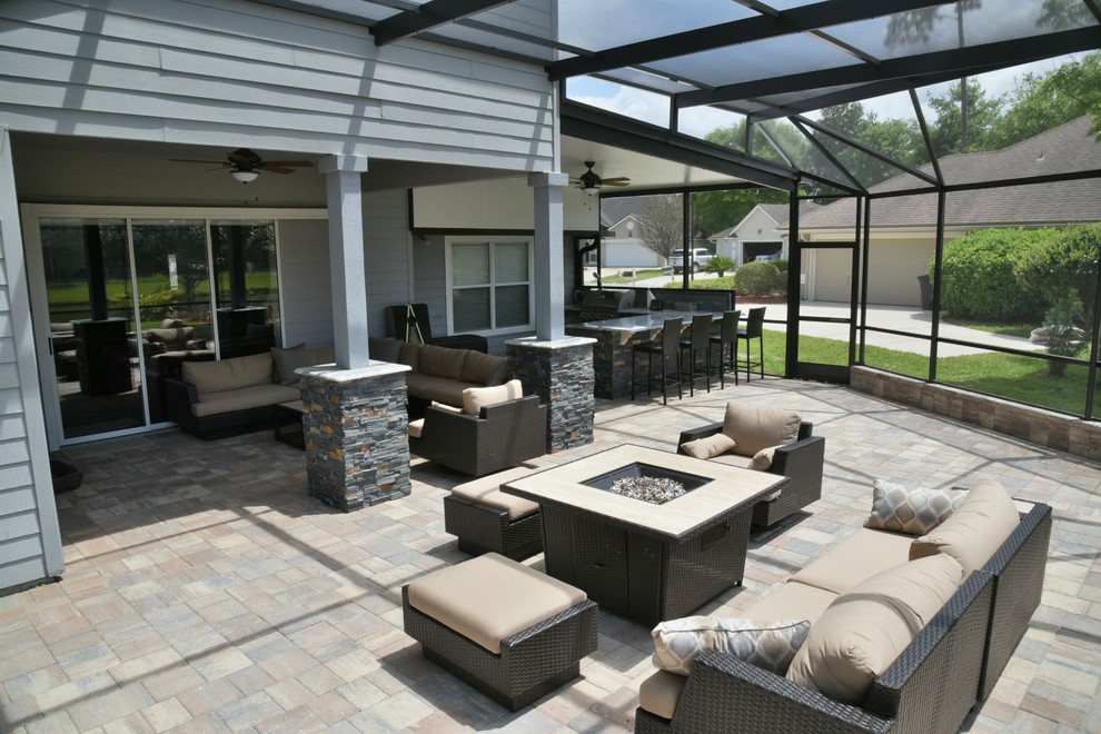 Foto de patio actual grande en patio trasero con cocina exterior, adoquines de piedra natural y toldo