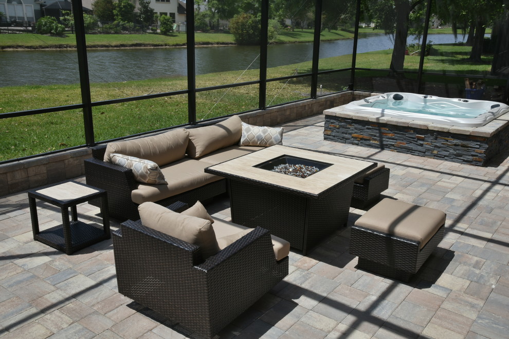 Inspiration pour une grande terrasse arrière design avec une cuisine d'été, des pavés en pierre naturelle et un auvent.