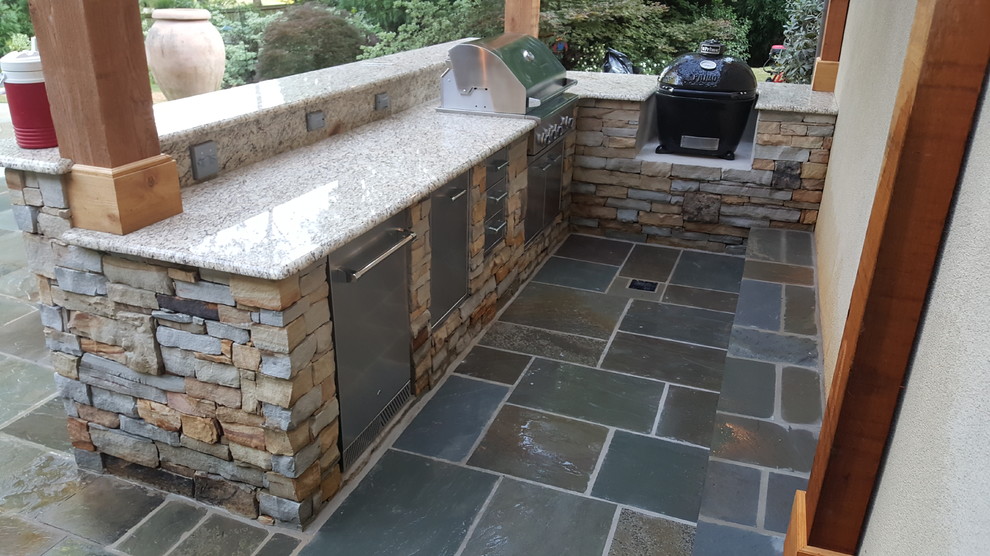Photo of a medium sized rustic back patio in Atlanta with an outdoor kitchen, natural stone paving and a pergola.