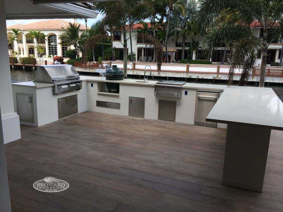 Inspiration for an expansive contemporary side patio in Miami with an outdoor kitchen, decking and no cover.
