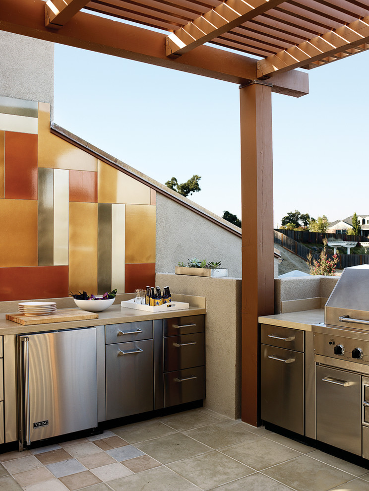 Aménagement d'une grande terrasse arrière classique avec une cuisine d'été, du carrelage et une pergola.