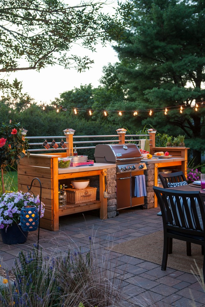 Small urban backyard brick patio kitchen photo in Other