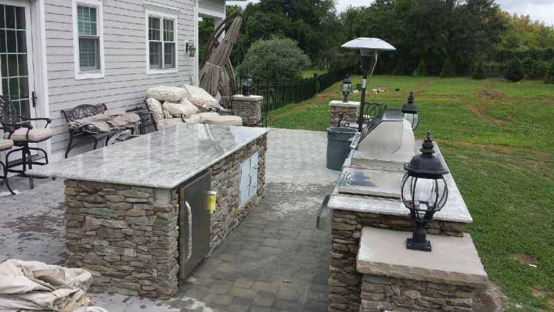 Photo of an expansive mediterranean back patio in New York with an outdoor kitchen, concrete paving and no cover.