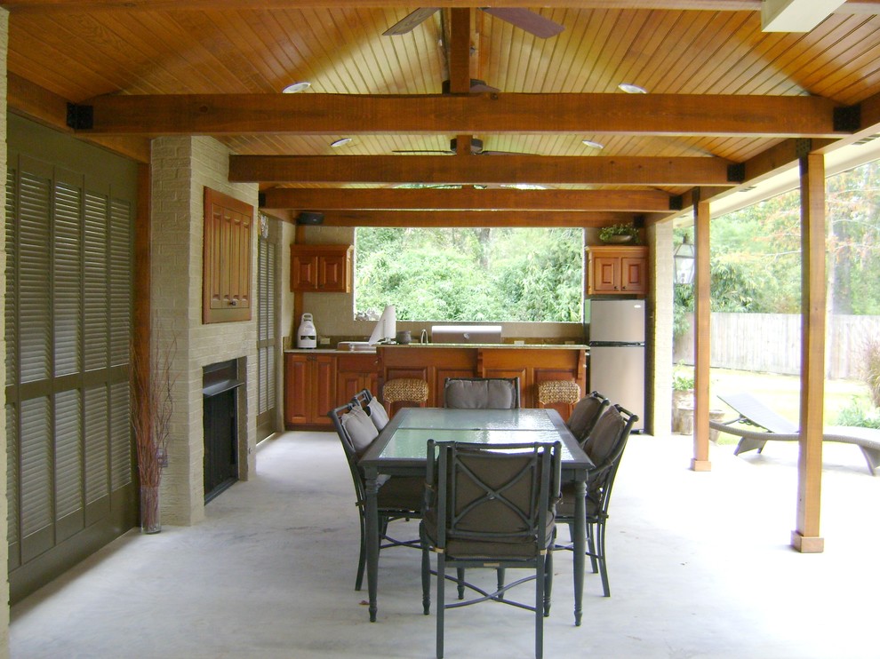 Idee per un grande patio o portico american style dietro casa con lastre di cemento e un tetto a sbalzo