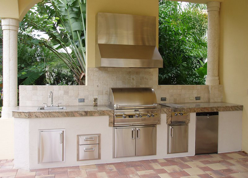 Example of a mid-sized tuscan backyard tile patio kitchen design in Los Angeles with a roof extension