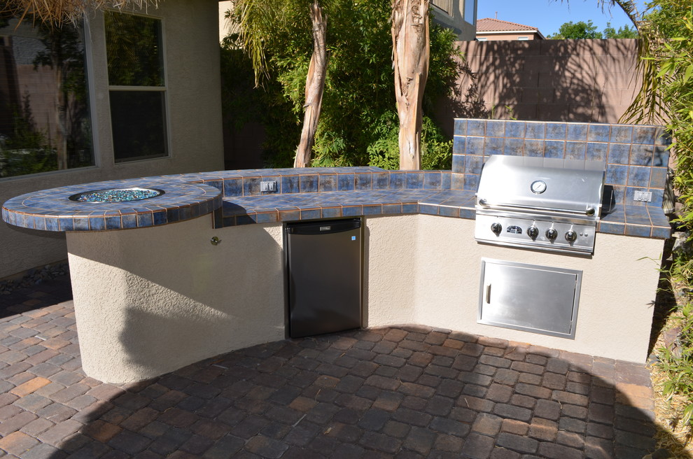 Inspiration for a large mediterranean back patio in Las Vegas with an outdoor kitchen, no cover and natural stone paving.