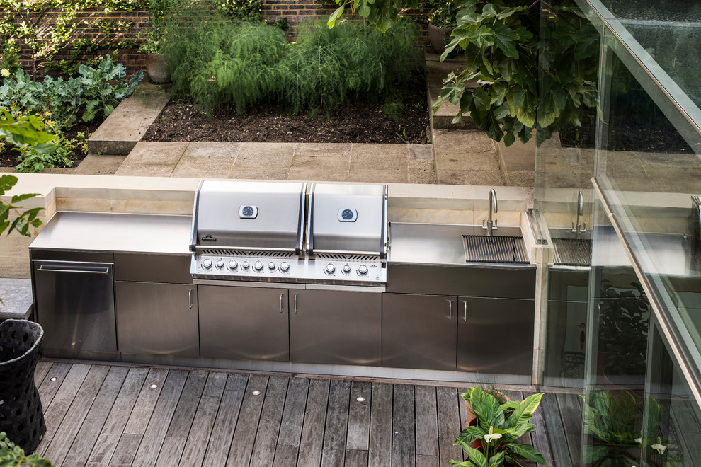Photo of an eclectic back patio in London with an outdoor kitchen and no cover.