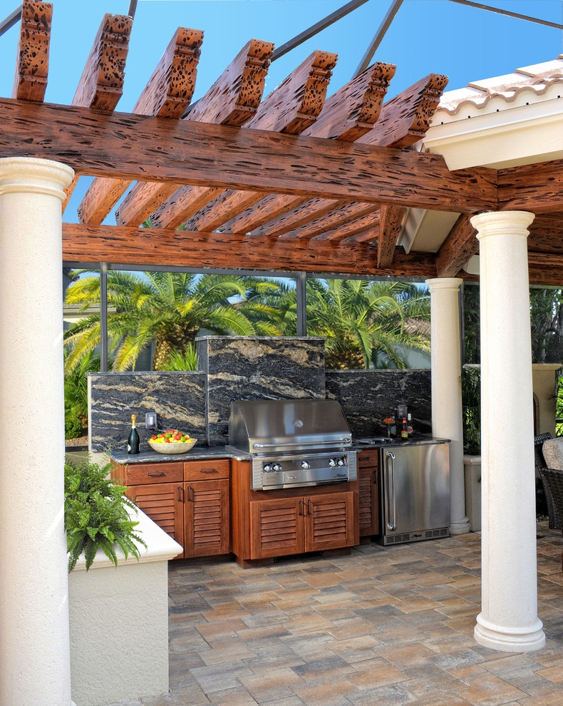 На фото: большой двор на заднем дворе в средиземноморском стиле с летней кухней, мощением тротуарной плиткой и навесом с