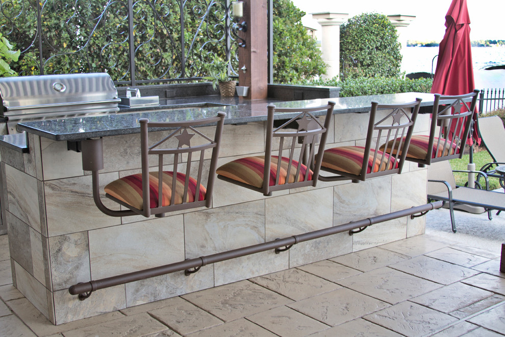 Cette image montre une terrasse arrière rustique de taille moyenne avec une cuisine d'été, du carrelage et une pergola.