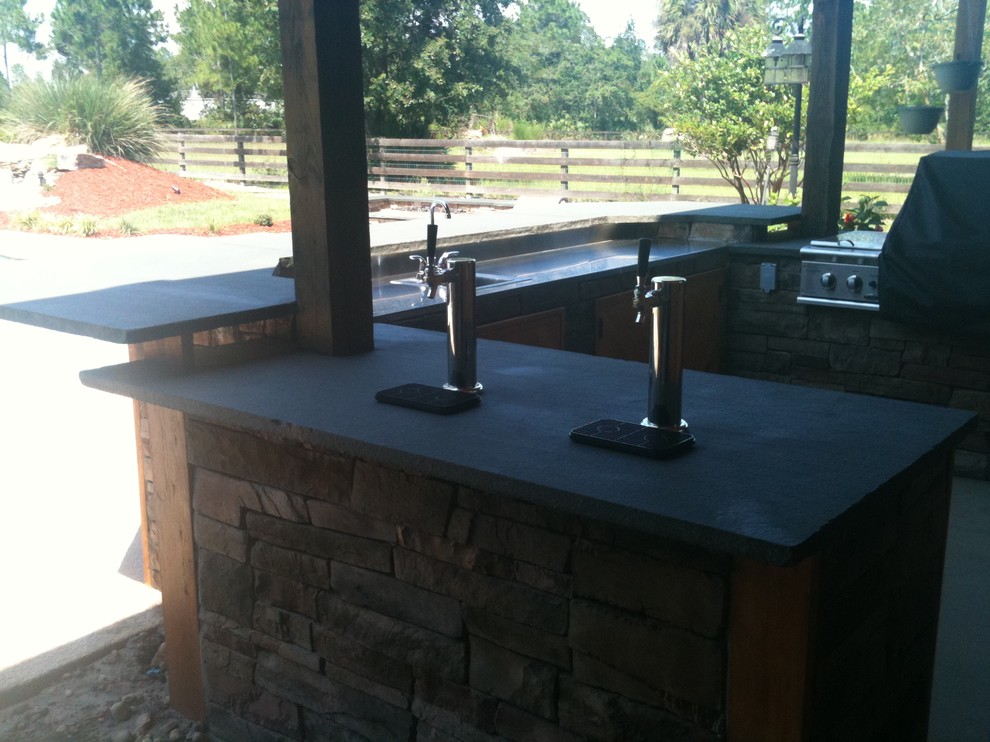 Patio kitchen - mid-sized rustic backyard concrete patio kitchen idea in Jacksonville with a roof extension