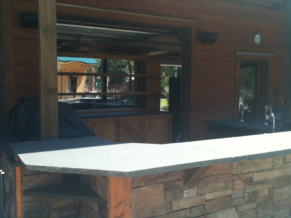 Cette photo montre une terrasse arrière montagne de taille moyenne avec une cuisine d'été, une dalle de béton et une extension de toiture.