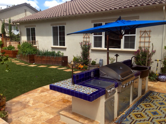 Exemple d'une terrasse arrière éclectique de taille moyenne avec une cuisine d'été, des pavés en pierre naturelle et aucune couverture.