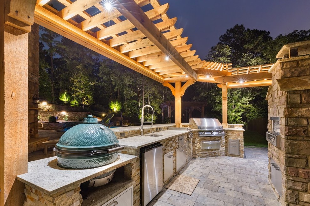 Inspiration pour une grande terrasse arrière chalet avec une cuisine d'été, des pavés en pierre naturelle et une pergola.