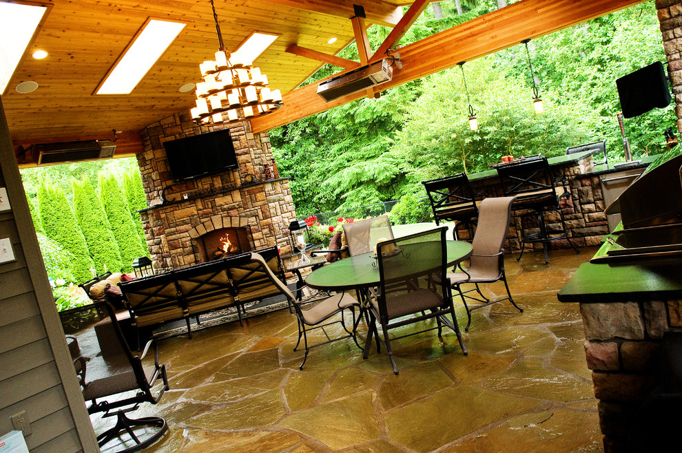 Inspiration for a mid-sized timeless backyard stone patio remodel in Seattle with a fire pit and a roof extension