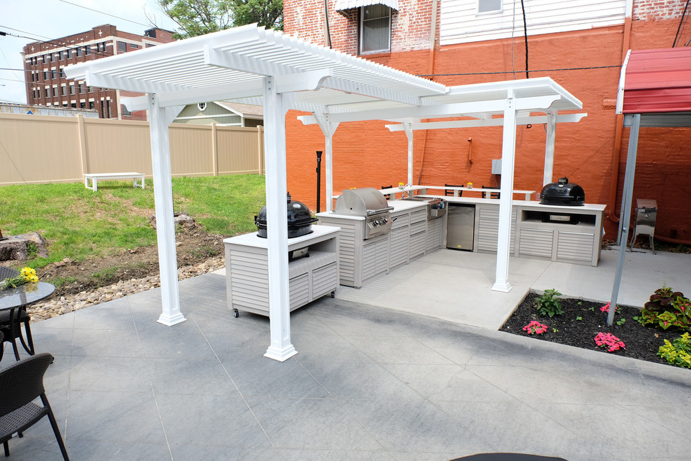 Immagine di un patio o portico minimal di medie dimensioni e dietro casa con cemento stampato e una pergola
