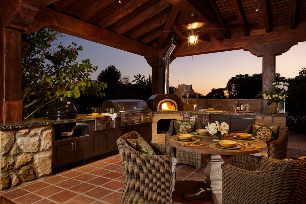 Aménagement d'une terrasse montagne avec une cuisine d'été, du carrelage et un gazebo ou pavillon.