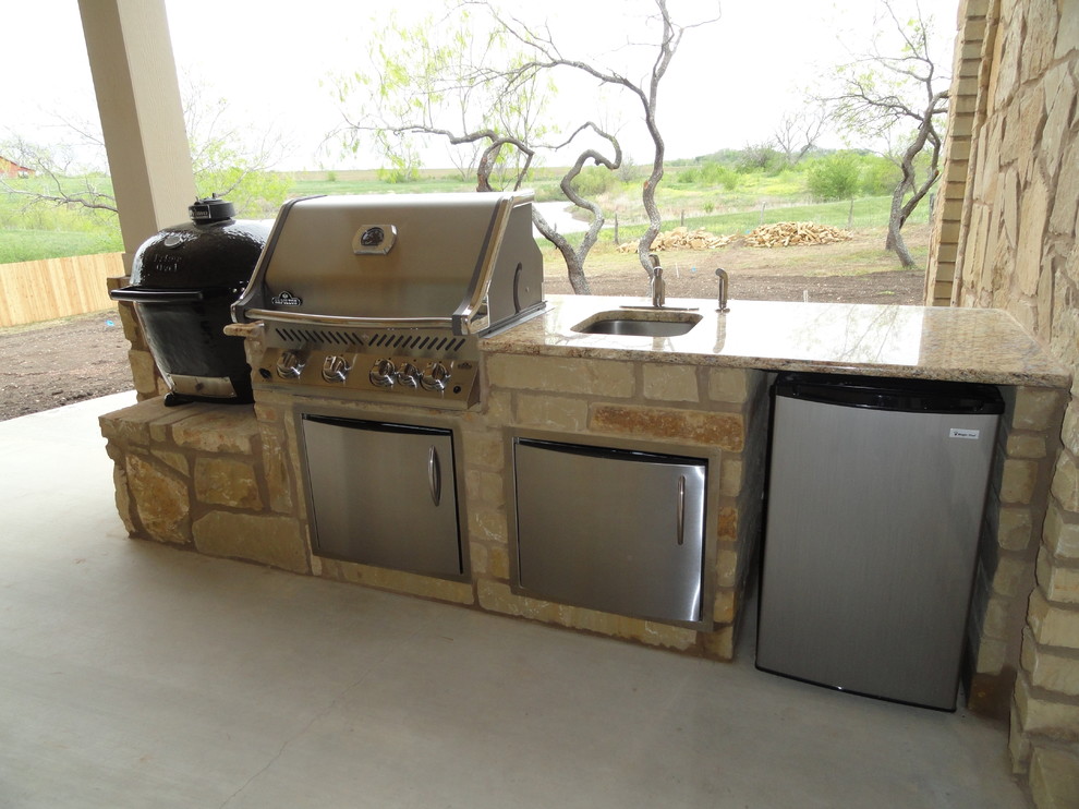 Photo of a large rustic back patio in Austin with an outdoor kitchen, concrete slabs and a roof extension.