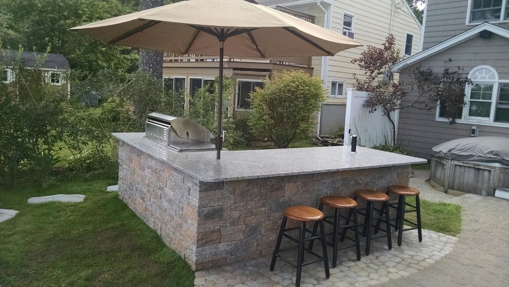 Example of a small beach style backyard concrete paver patio kitchen design in Manchester with no cover