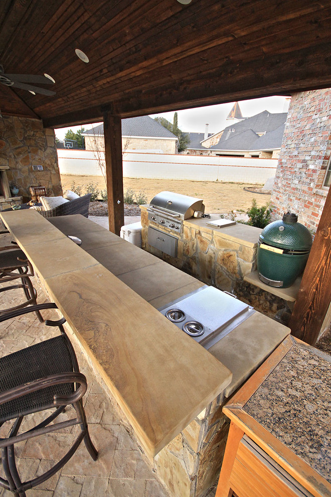 Inspiration for a medium sized world-inspired back patio in Dallas with an outdoor kitchen, concrete paving and no cover.