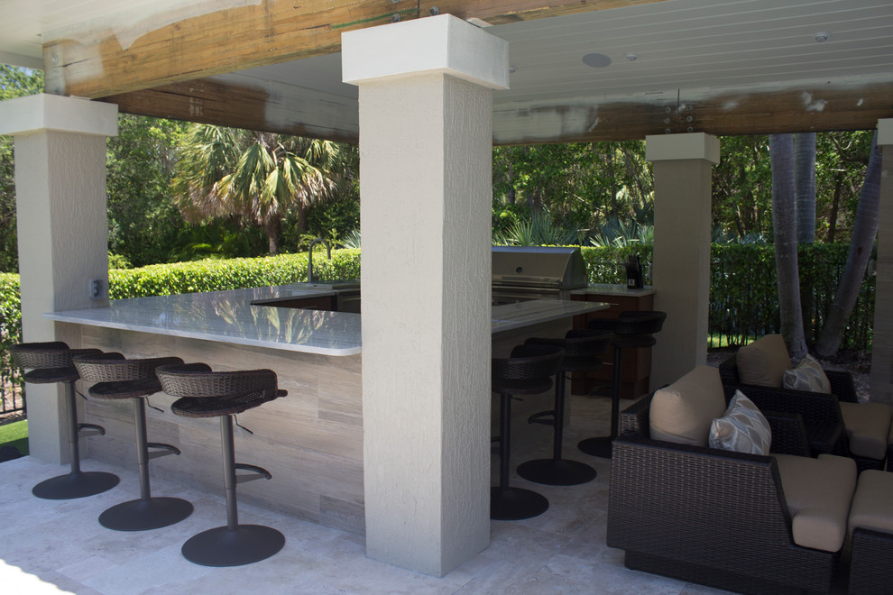 Inspiration for a large traditional back patio in Miami with an outdoor kitchen, natural stone paving and a gazebo.