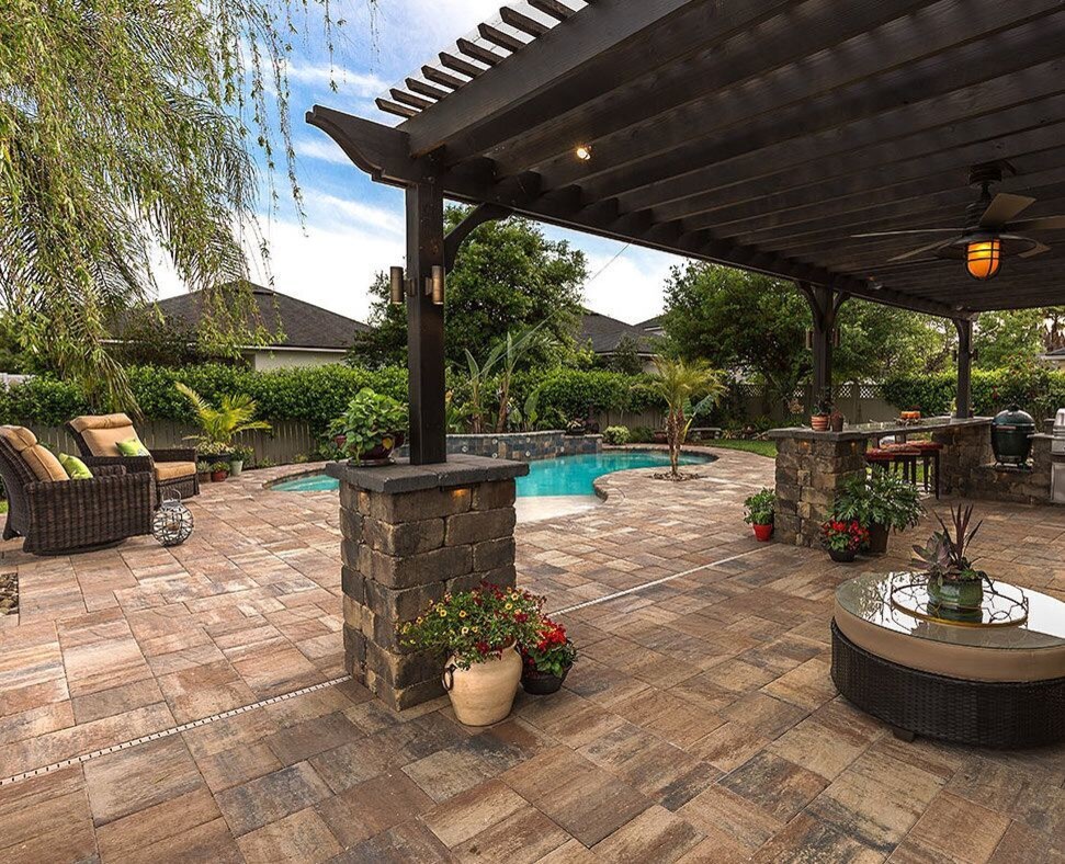 Example of a mid-sized classic backyard concrete paver patio kitchen design in Tampa with a pergola