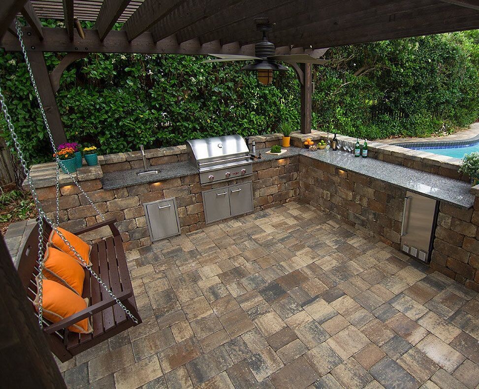 Mid-sized elegant backyard concrete paver patio kitchen photo in Tampa with a pergola
