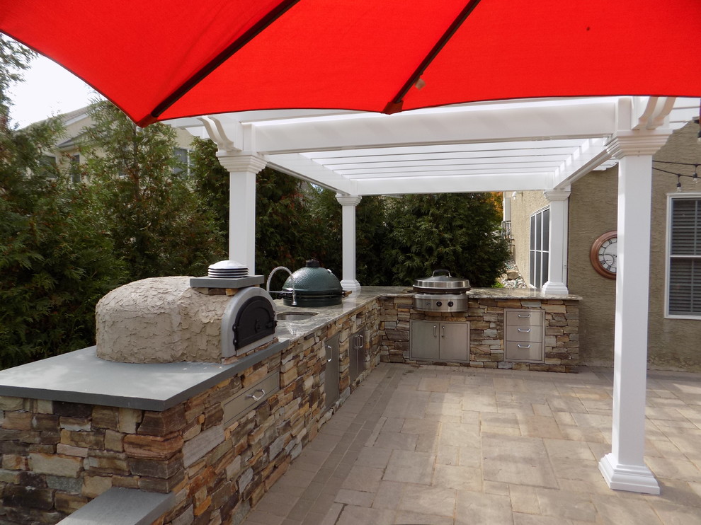 Foto de patio minimalista grande en patio trasero con cocina exterior, adoquines de hormigón y pérgola