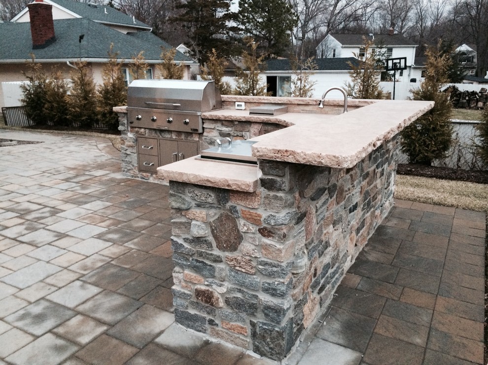 Example of a mid-sized mountain style backyard concrete paver patio kitchen design in New York with no cover