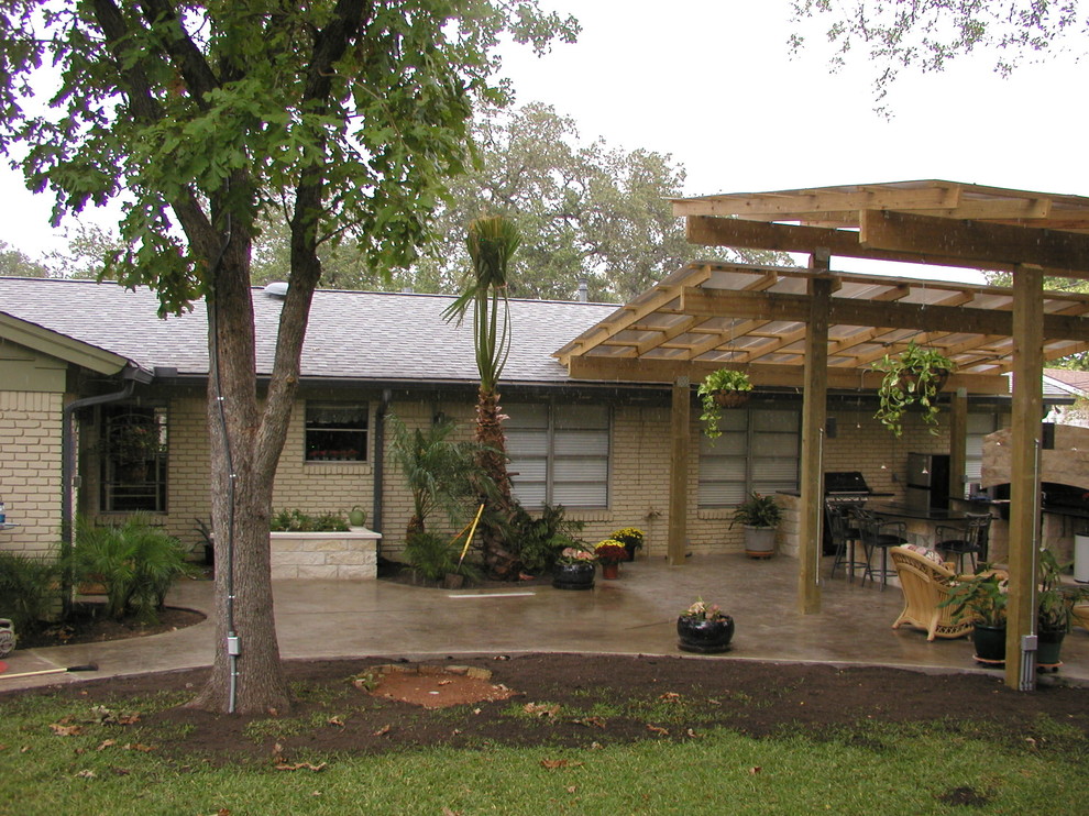 Photo of a medium sized classic back patio in Austin with an outdoor kitchen, concrete slabs and a pergola.