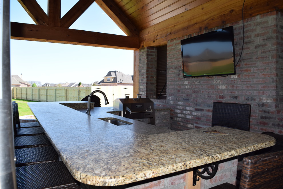 Exemple d'une terrasse arrière craftsman de taille moyenne avec une cuisine d'été, des pavés en brique et un gazebo ou pavillon.