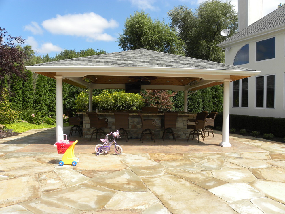 Inspiration for a huge timeless backyard stone patio kitchen remodel in Chicago with a gazebo