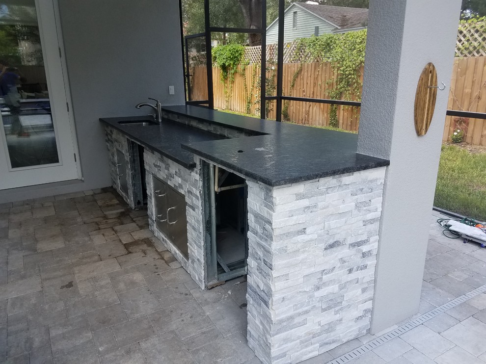 Medium sized rustic back patio in Tampa with an outdoor kitchen, concrete paving and a roof extension.