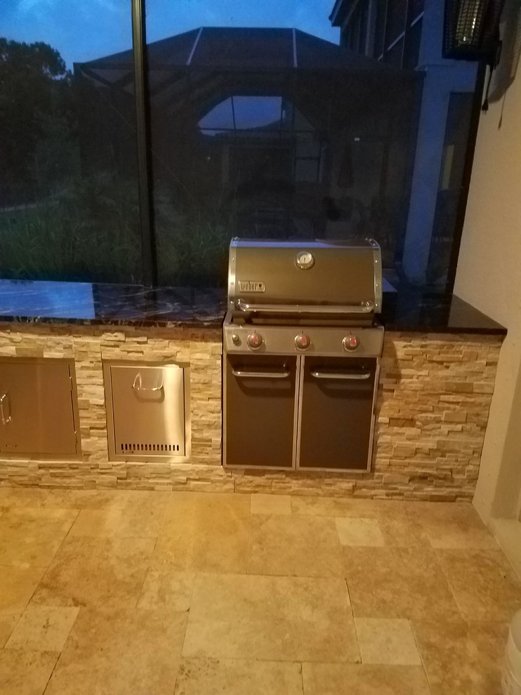 Mid-sized mountain style backyard stone patio kitchen photo in Tampa with a roof extension