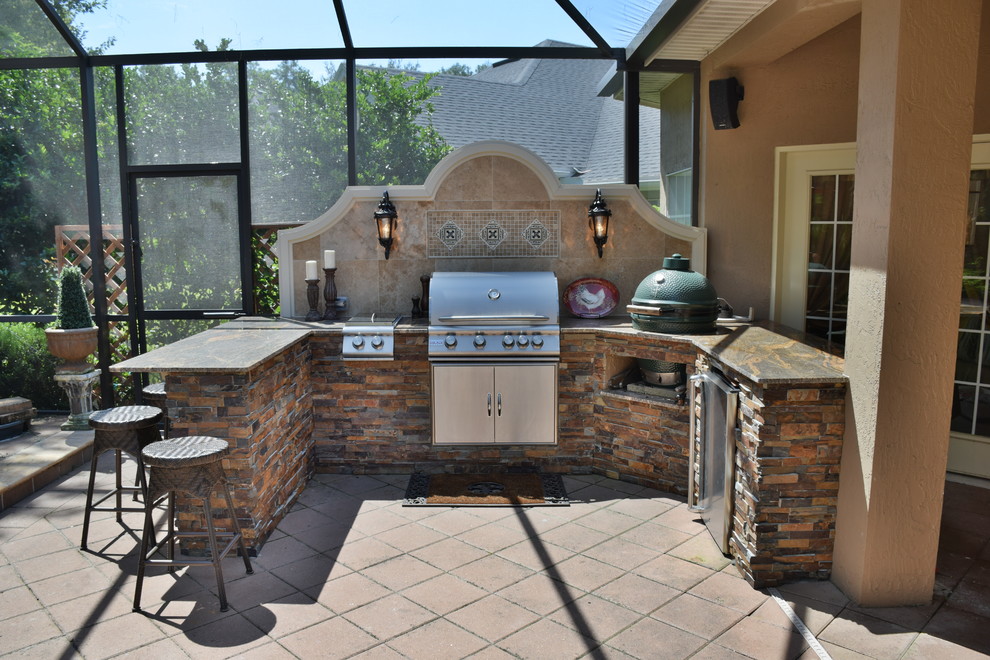 Cette photo montre une très grande terrasse arrière chic avec une cuisine d'été et du carrelage.