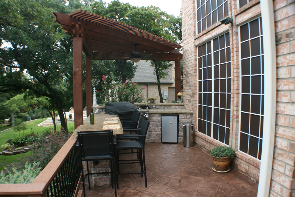 Aménagement d'une terrasse arrière classique de taille moyenne avec une cuisine d'été, du béton estampé et une pergola.