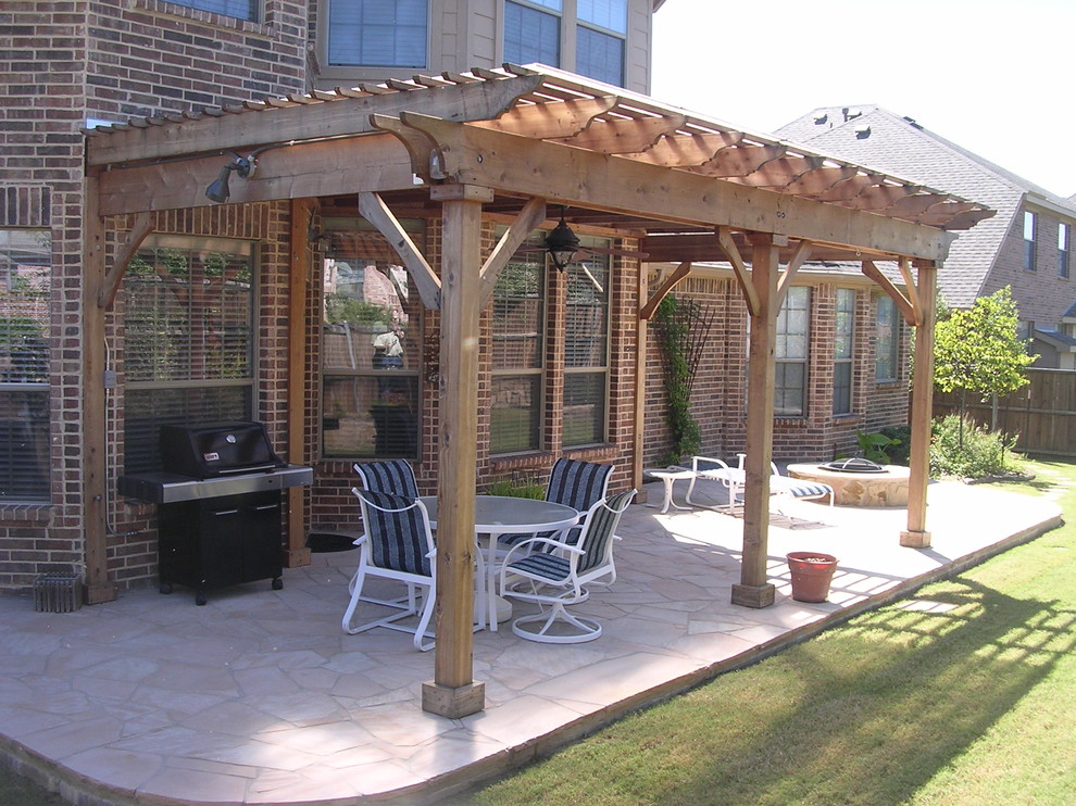 Diseño de patio clásico de tamaño medio en patio trasero con adoquines de piedra natural y pérgola