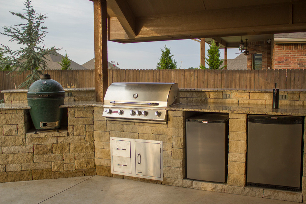 Mid-sized backyard stone patio kitchen photo in Oklahoma City with a roof extension