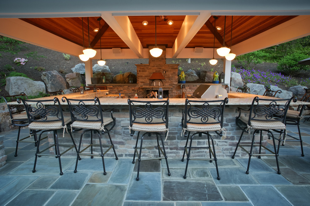 Foto de patio clásico grande en patio trasero y anexo de casas con adoquines de piedra natural