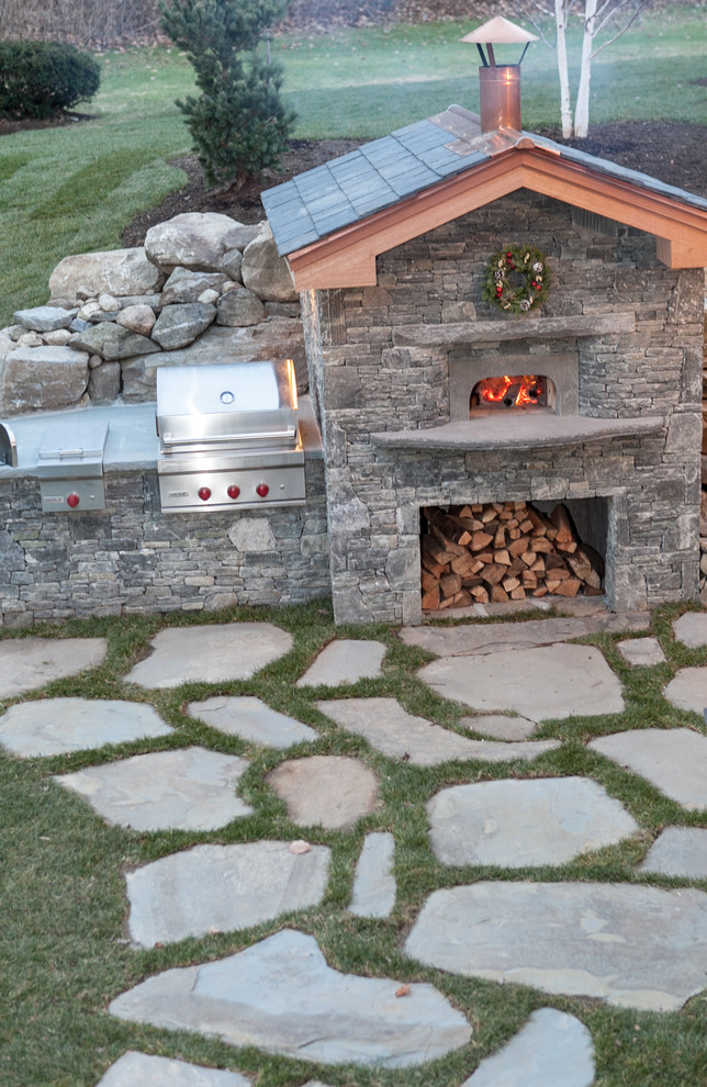 Photo of a medium sized rustic back patio in Boston with natural stone paving and no cover.