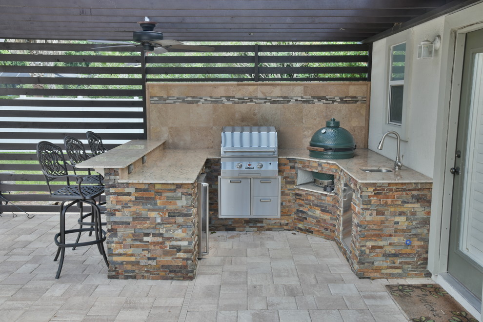 This is an example of a medium sized contemporary back patio in Jacksonville with an outdoor kitchen, concrete paving and a pergola.