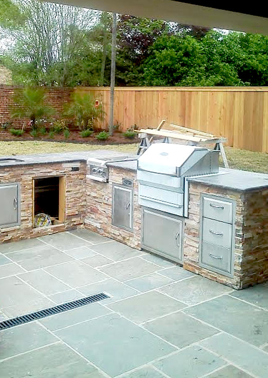 Example of a large classic backyard tile patio kitchen design in New Orleans with no cover