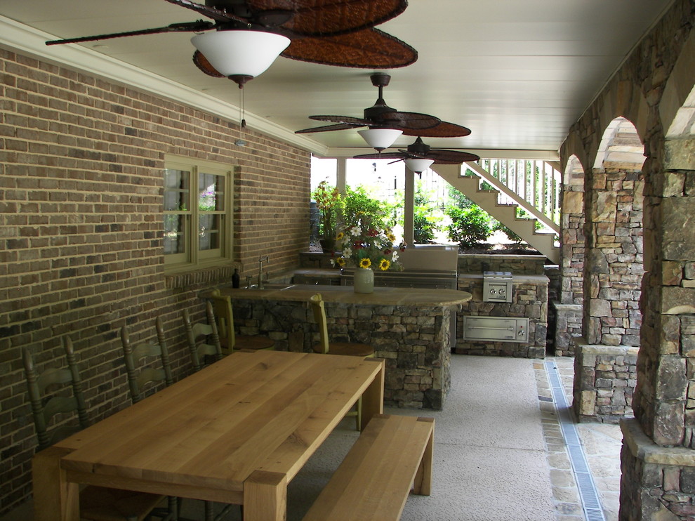Large tuscan backyard concrete patio kitchen photo in Atlanta with a roof extension