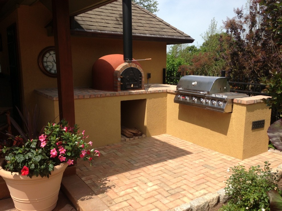 Example of a mid-sized classic backyard brick patio kitchen design in Phoenix with a roof extension