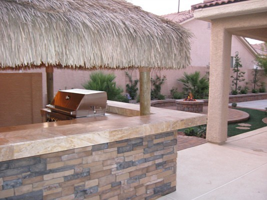Design ideas for a medium sized world-inspired back patio in Las Vegas with an outdoor kitchen and an awning.
