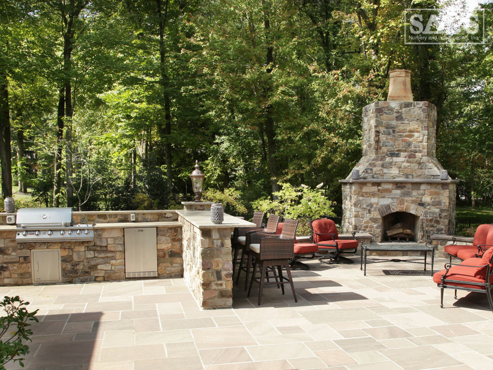Modelo de patio clásico de tamaño medio sin cubierta en patio trasero con cocina exterior y adoquines de piedra natural