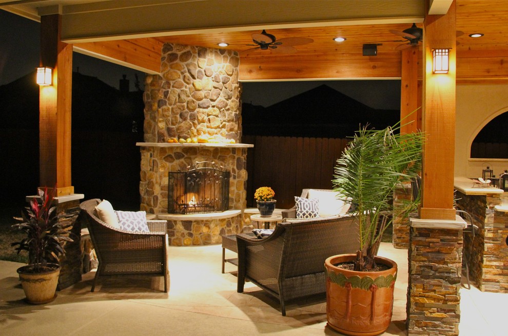 Patio - large contemporary backyard stone patio idea in Houston with a fire pit and a roof extension